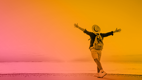Man on beach with arms spread wide towards the sun plus marigold/coral pink overlay