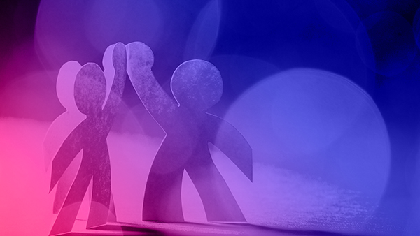 Abstract image of cardboard cut-out people high-fiving with gradient overlay