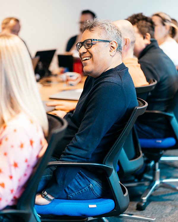 Who we are - colour photos of a smiling Zahid Bilgrami in a meeting